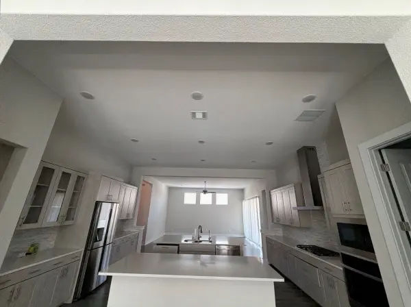 Bright, newly finished kitchen with white cabinetry, quartz countertops, gray tile backsplash, stainless steel appliances, and recessed lighting in Briarcliff, TX.